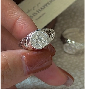 Macro shot of S925 silver hex signet ring with star engraving and hammered texture