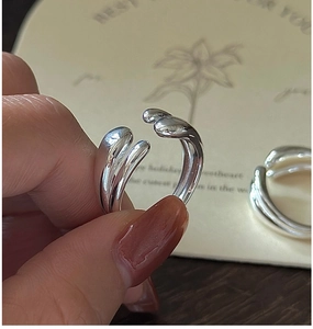 Close-up of a minimalist adjustable S925 sterling silver ring with a crossover design