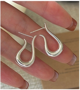 Close-up of S925 sterling silver U-shaped curved earrings with high-polished finish