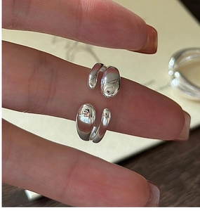 Macro detail of silver crossover open ring with polished pebble ends and minimalist texture