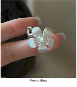 Close-up of S925 silver flower ring with brushed texture and central white pearl accent