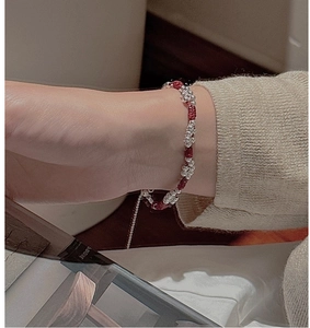 Close-up of S925 sterling silver beads on a red woven bracelet worn on a wrist