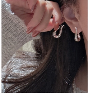 Close-up of elegant S925 sterling silver curved hook earrings on a female model