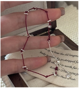Bracelet en corde tressée rouge avec perles argentées et breloque en zircone cubique