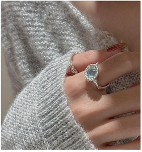 Primo piano dell'anello in argento S925 con gemma blu e trama a petalo di girasole vintage
