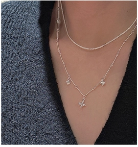 Detailed view of layered S925 silver necklaces with floral pendants and tennis chain