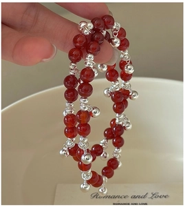 Detail of S925 silver beads and red agate stones on a multi-layer beaded bracelet