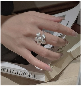 Detailed view of S925 silver flower ring with central pearl and brushed metal texture