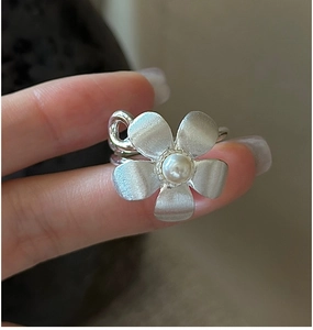 Macro detail of S925 sterling silver flower ring with pearl and matte brushed texture