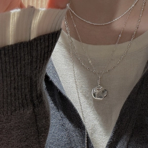 Dreilagige S925 Sterling Silber Halskette mit Lava-Anhänger auf weißem Strickpullover