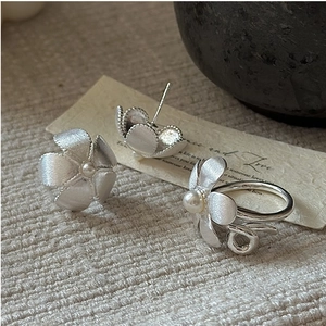 Macro detail of S925 silver flower jewelry set with matte texture and small pearls