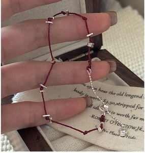 Détail du bracelet en corde rouge tressée avec accents en argent S925 et zircon