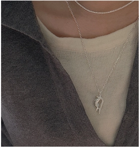 Detail of layered S925 sterling silver necklaces with fluid pendant on minimalist model