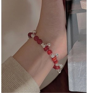 Close-up of S925 sterling silver beaded bracelet with carved red agate rose and small charms