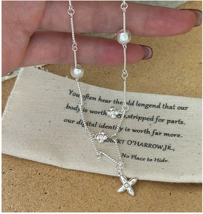 Detailed close-up of a vintage matte S925 silver necklace with floral pendants on linen