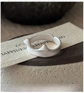 Macro shot of minimalist S925 sterling silver irregular wave ring with matte texture