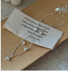 Detailed macro view of S925 sterling silver floral necklace on brown cork background