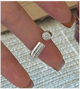 Macro shot of S925 sterling silver open ring with a round zircon and metal cylinder