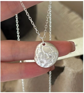 Detail of S925 sterling silver hammered pendant necklace with white zircon accents