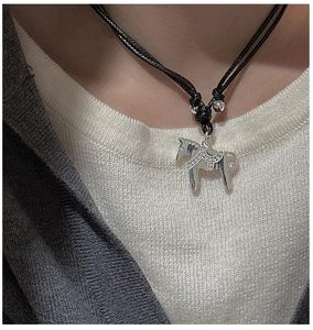 Détail du pendentif cheval Dala en argent S925 porté sur un collier cordon noir tressé