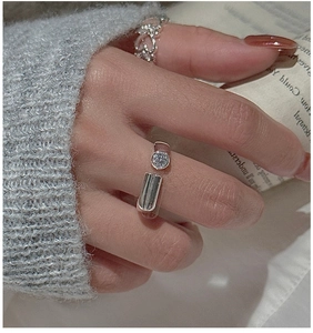 Detail of S925 sterling silver open ring with zircon inlay and geometric bar on hand