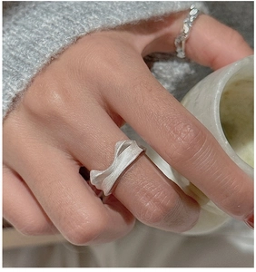Close-up of minimalist S925 sterling silver wavy ring with a brushed matte texture