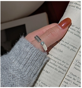 Detail of S925 sterling silver minimalist ring with cubic zirconia on a female finger
