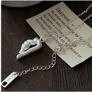 Macro shot of S925 sterling silver necklace detail with abstract twisted pendant and tag
