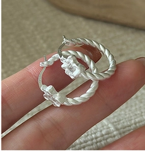 Detailed close-up of S925 sterling silver twist hoop earring showing authenticity hallmark
