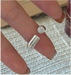 Macro detail of S925 silver open ring featuring a brilliant round zircon and polished bar