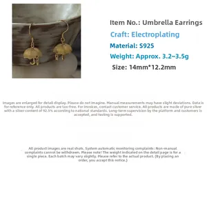 Macro detail of gold-plated S925 sterling silver umbrella earrings with textured edges