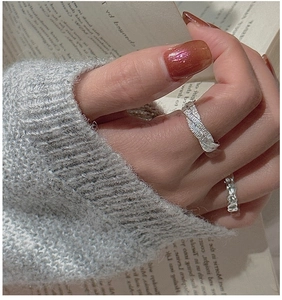 Macro shot of S925 sterling silver rings with vintage hammered texture and feather patterns