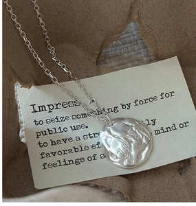 Macro view of S925 sterling silver necklace with textured irregular round pendant