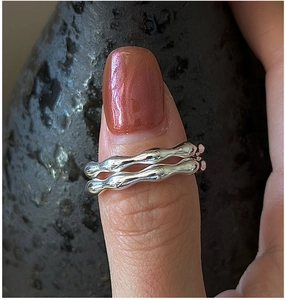 Close-up of S925 sterling silver ring with organic wave texture and polished mirror finish