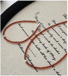 Vue détaillée du bracelet en perles de spinelle rouge avec fermoir coeur sur fond vintage