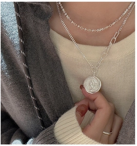 Close-up of S925 silver vintage portrait coin pendant with layered mixed chain detail