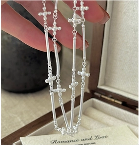 Détail du collier croix en argent S925 montrant la texture mate et le motif étoile