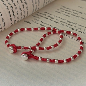 Minimalist S925 sterling silver beads and red woven rope bracelet on vintage book