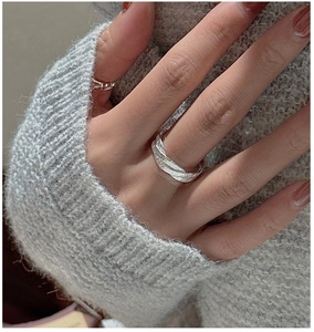 Detailed view of an S925 sterling silver ring with handmade hammered texture on a hand