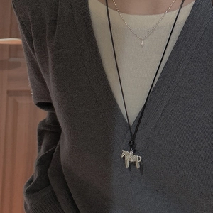 Collier pendentif cheval en argent S925 avec cordon noir sur un pull gris chiné