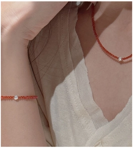 Macro shot of S925 silver beaded necklace and bracelet set with red faceted gemstones