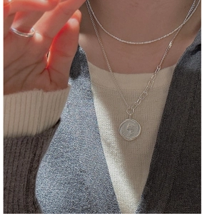 Silver layered necklace set featuring a vintage coin pendant and a horseshoe choker chain