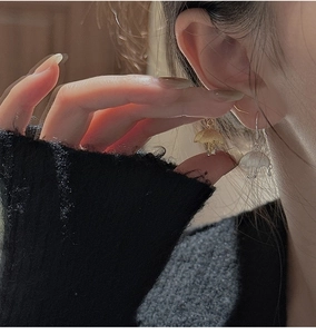 Detail view of S925 sterling silver umbrella earrings worn on model showing scale