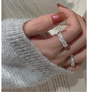 Detail of silver S925 ring with molten lava texture on an open book background