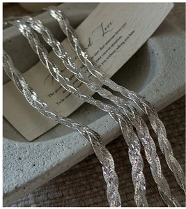 Macro detail of S925 sterling silver woven bracelet featuring a layered spiral texture