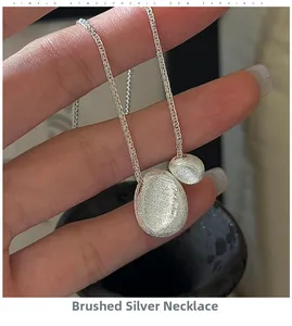 Macro shot of S925 sterling silver brushed bean necklace with fine handcrafted texture