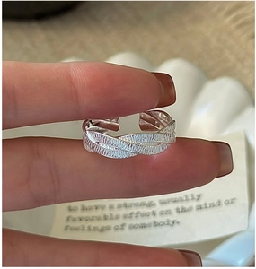 Detailed view of silver braided texture ring with adjustable open design on hand