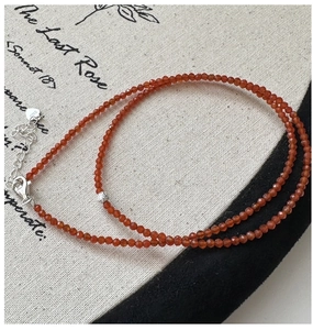 Detailed macro view of S925 silver clasp and orange spinel beads on the necklace