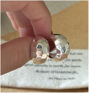 Macro shot of silver S925 earrings with unique honeycomb faceted texture for women