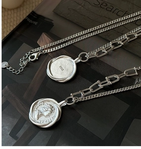 Detail of S925 sterling silver necklace showing portrait coin and material hallmark